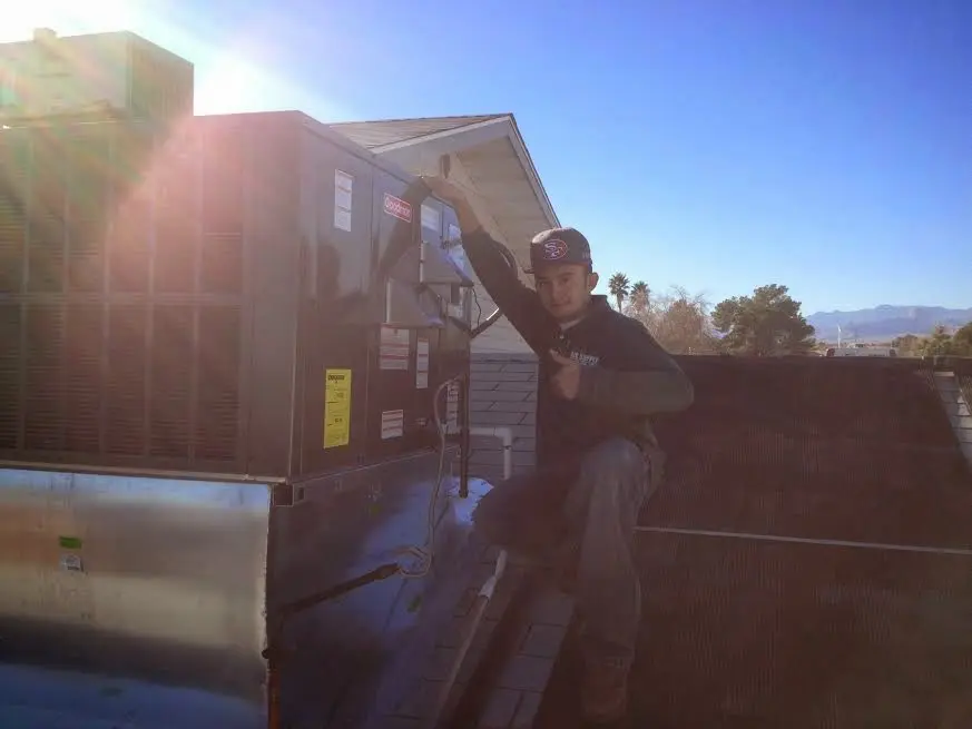 HVAC technician performing Air Duct Cleaning on a rooftop unit in Kings Point